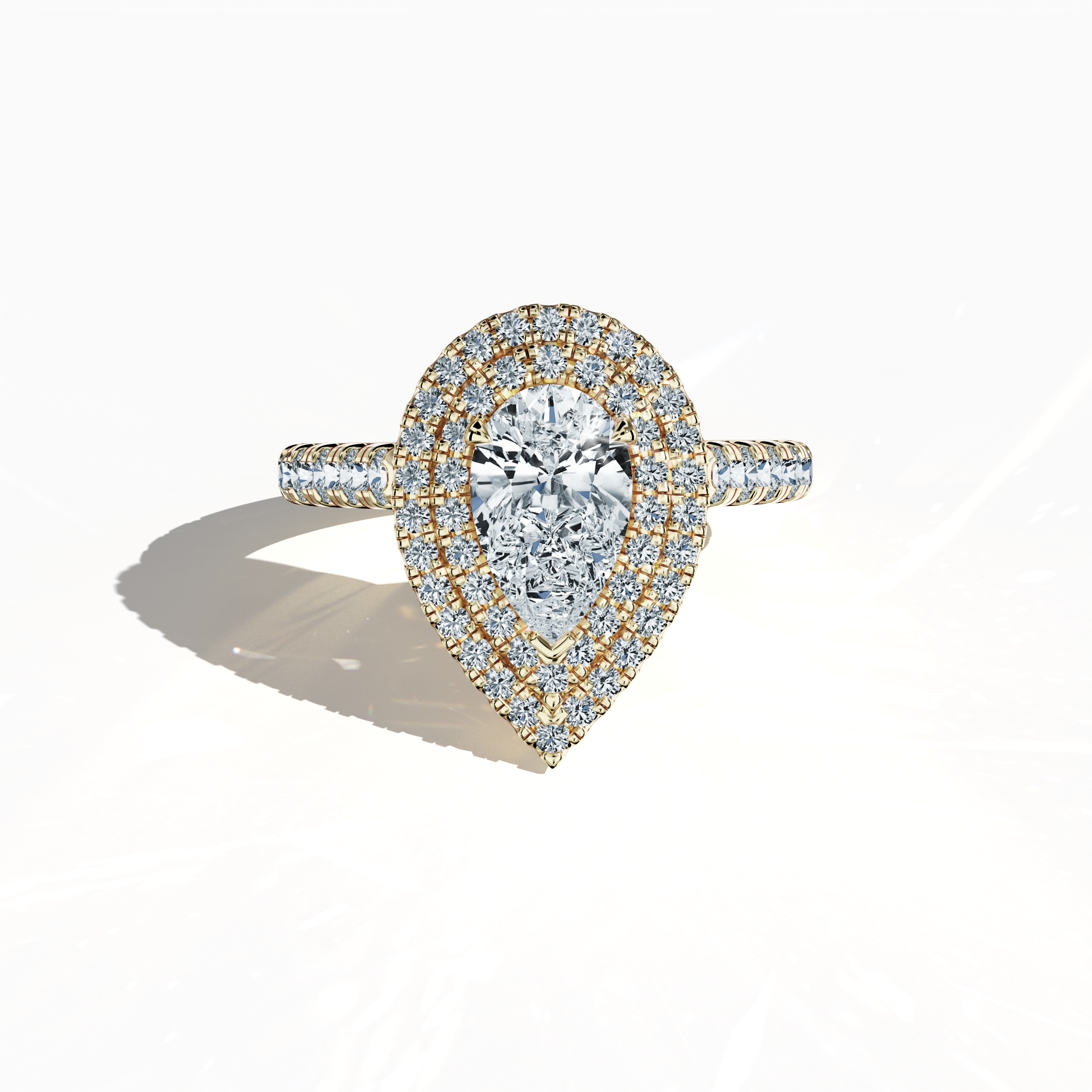 Image of a dazzling double halo diamond ring in radiant yellow gold (also known as classic gold or sunlit gold) presented in a sleeping front view on a smooth surface. The ring features a brilliant 1ct pear‐cut center diamond—alternatively called teardrop or waterdrop—encircled by up to 1ct of meticulously paved side diamonds. With design elements including double halo, pavé halo, twin halo, cathedral halo, vintage halo, and contemporary halo, it exudes opulence, refined craftsmanship, and international ele