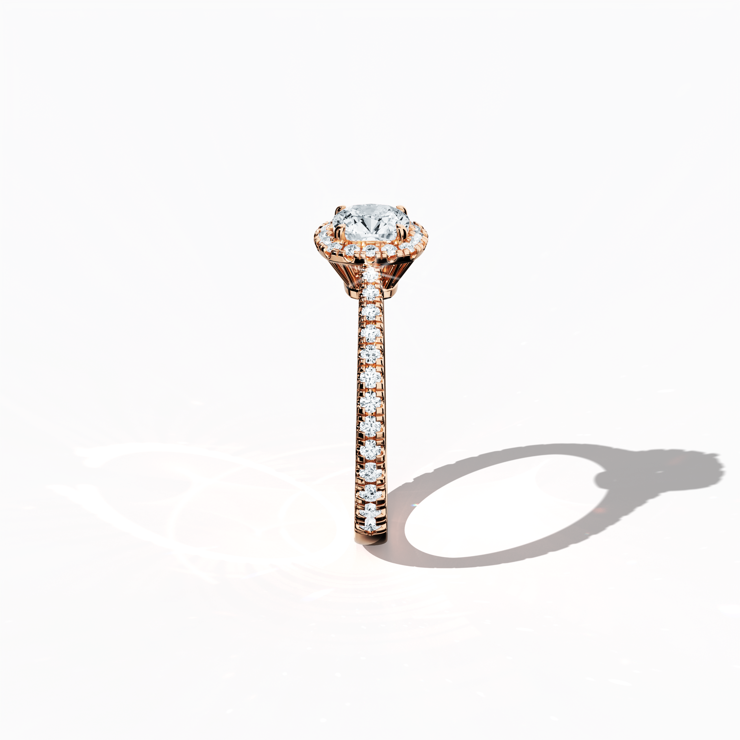 Revealed in a crisp standing side view, the halo paved diamond ring in enchanting rose gold exudes soft, romantic allure. The 1 ct cushion center diamond, encircled by a 0.60 ct halo of brilliant side stones for a total of 1.60 carats, is rendered in a design that merges Classic Halo, Eternity Halo, and Modern Halo influences with cushion and princess cut accents, all set in a warm, pink, blush finish. Keywords: luxury, sparkle, handcrafted, elegant, radiant.