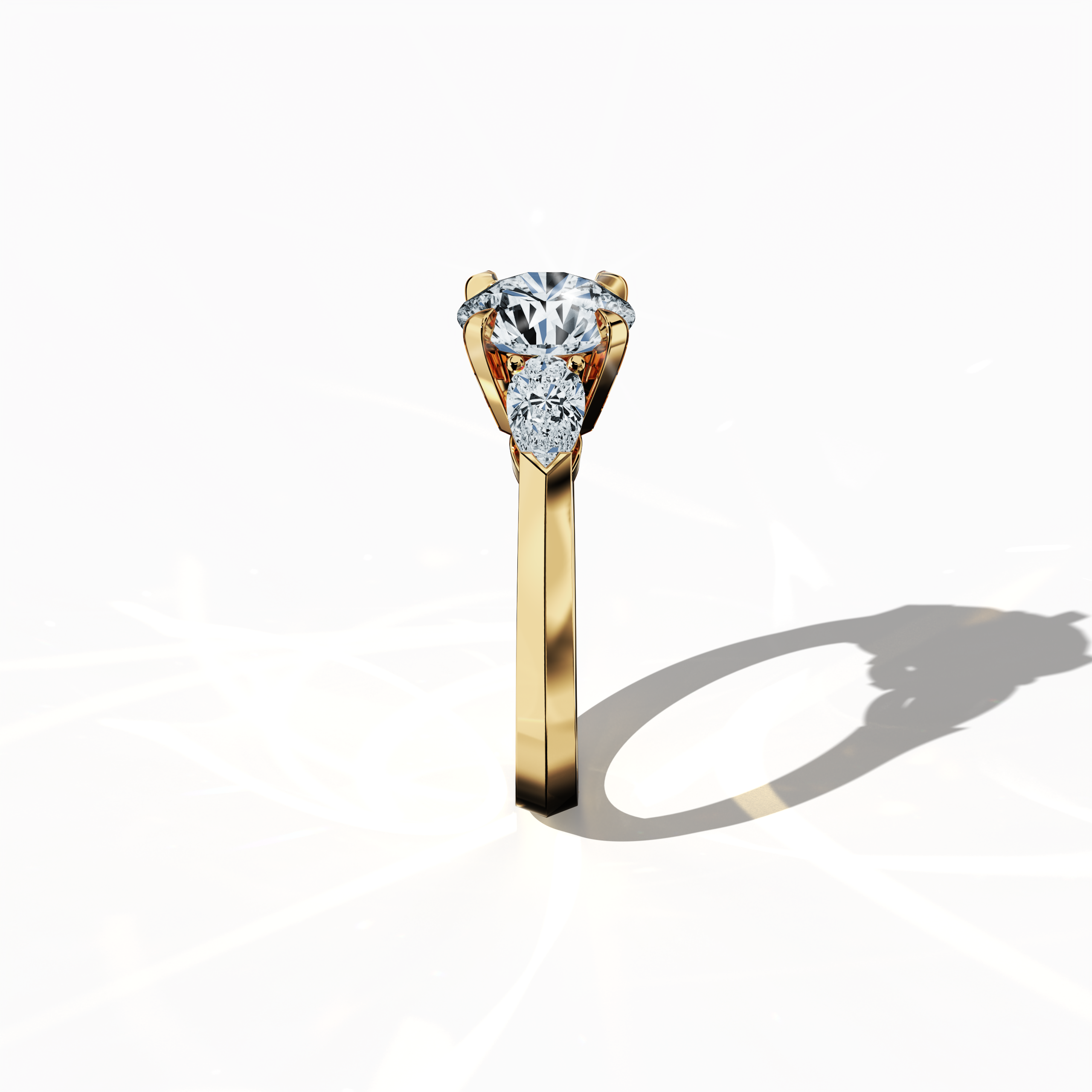 Side view of a yellow gold trilogy diamond ring highlighting 2.55 ct natural diamonds—a 2 ct round center/centre diamond flanked by two pear‐shaped side diamonds (0.55 ct total) in a refined slim band with a four‐nail prong setting. This perspective accentuates its elegant profile and luminous finish, perfect as an engagement ring, wedding band, or fine jewelry/fine jewellery accessory. Also known as a trilogy ring, three‐stone ring, three‐diamond ring, trinity ring, and triptych ring design.