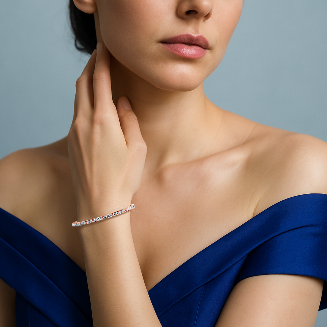 This 4-carat diamond tennis bracelet in rose gold (sometimes referred to as pink gold or red gold) is displayed on a woman's wrist, demonstrating its soft hue and brilliant sparkle. Also known as a line bracelet, eternity bracelet, river bracelet, or inline bracelet, it features prong-set round diamonds in a graceful row. Ideal for special moments or everyday style, it flatters a variety of outfits. Keywords: diamond tennis bracelet, rose gold, line bracelet.