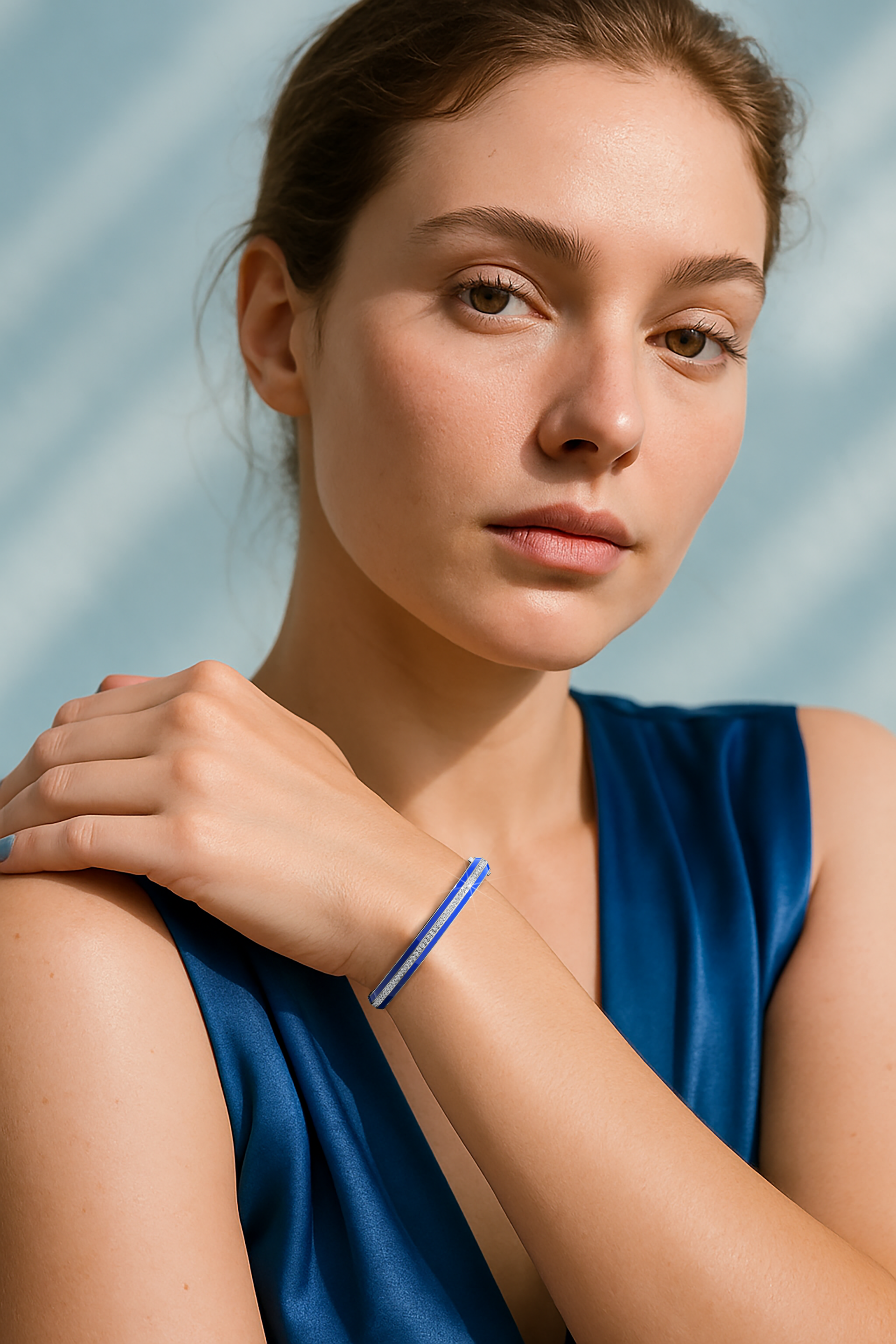 Side enamel center paved bangle in white gold (also called pale gold), with vibrant blue enamel, elegantly worn on a feminine wrist. Featuring 2.60 carats of diamonds in a pavé arrangement, this bracelet, armlet, kangan, or pulsera adds a luxurious accent to any ensemble. Its graceful design blends luminous gemstones with sleek enamel, exuding sophistication and versatility. Keywords: bangle, enamel, diamonds, white gold.

