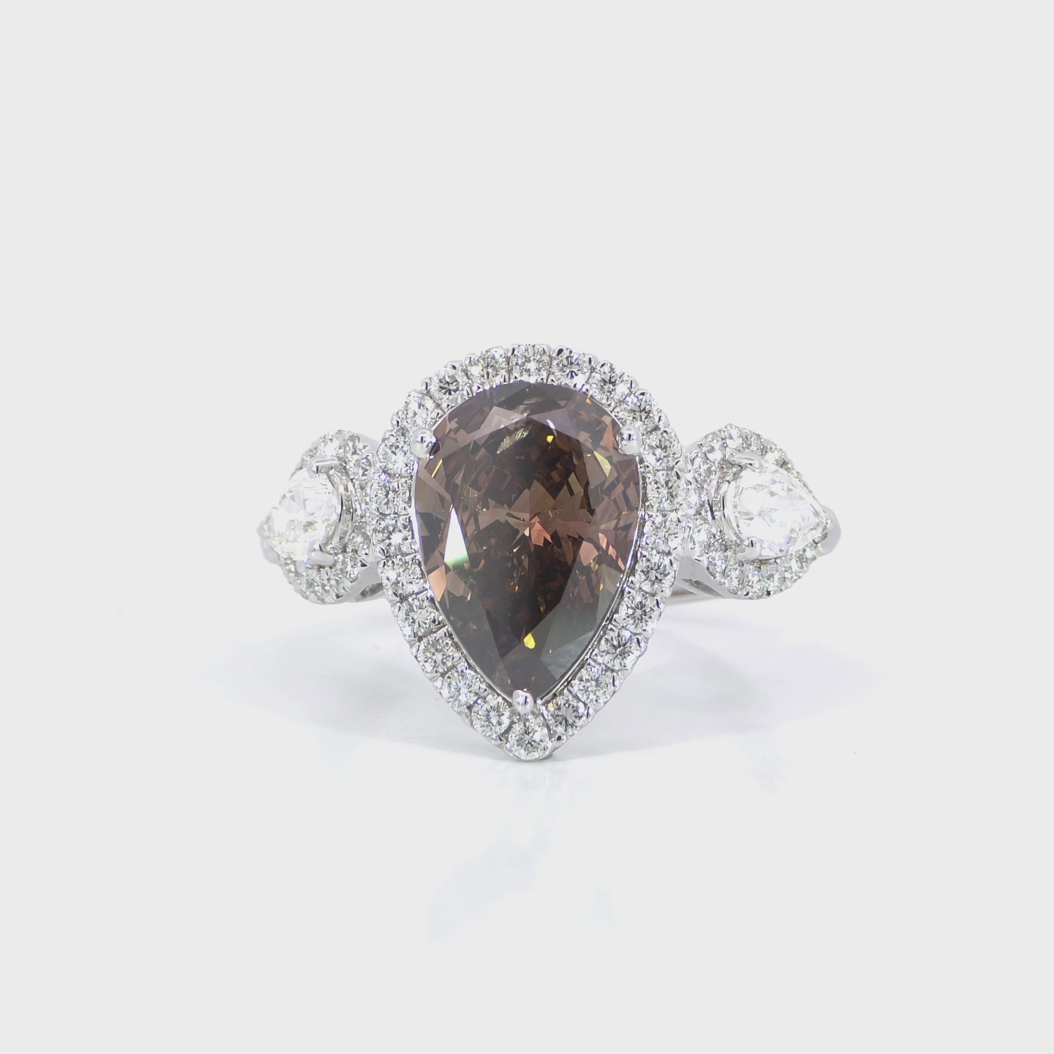 Brown diamond pear trio halo ring detailed video displaying trio halo setting and VVS-VS clarity side diamonds
